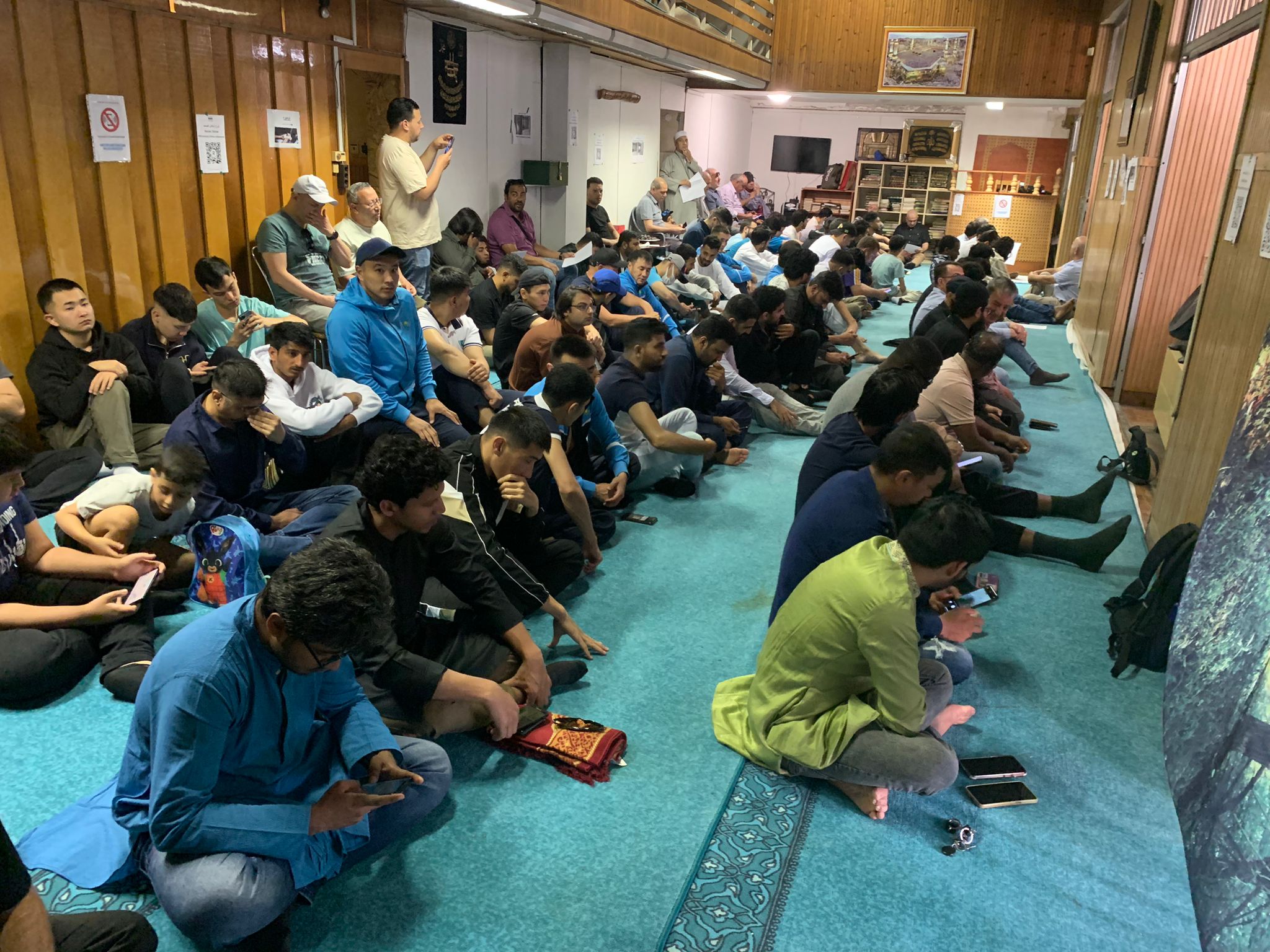 Wide view of the mosque prayer hall filled with attendees