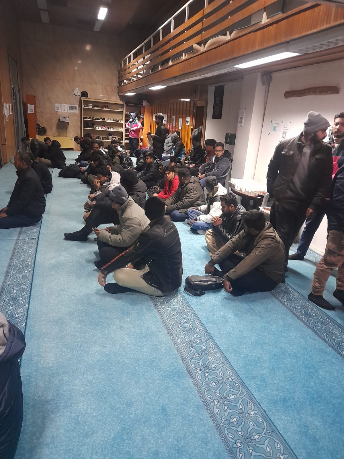 Attendees seated in rows inside the mosque
